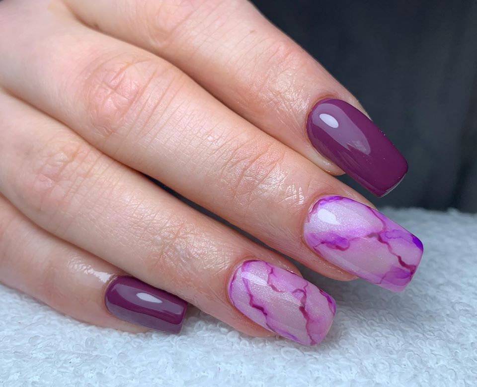 Paarse marmerlook nagels op een witte donzige ondergrond