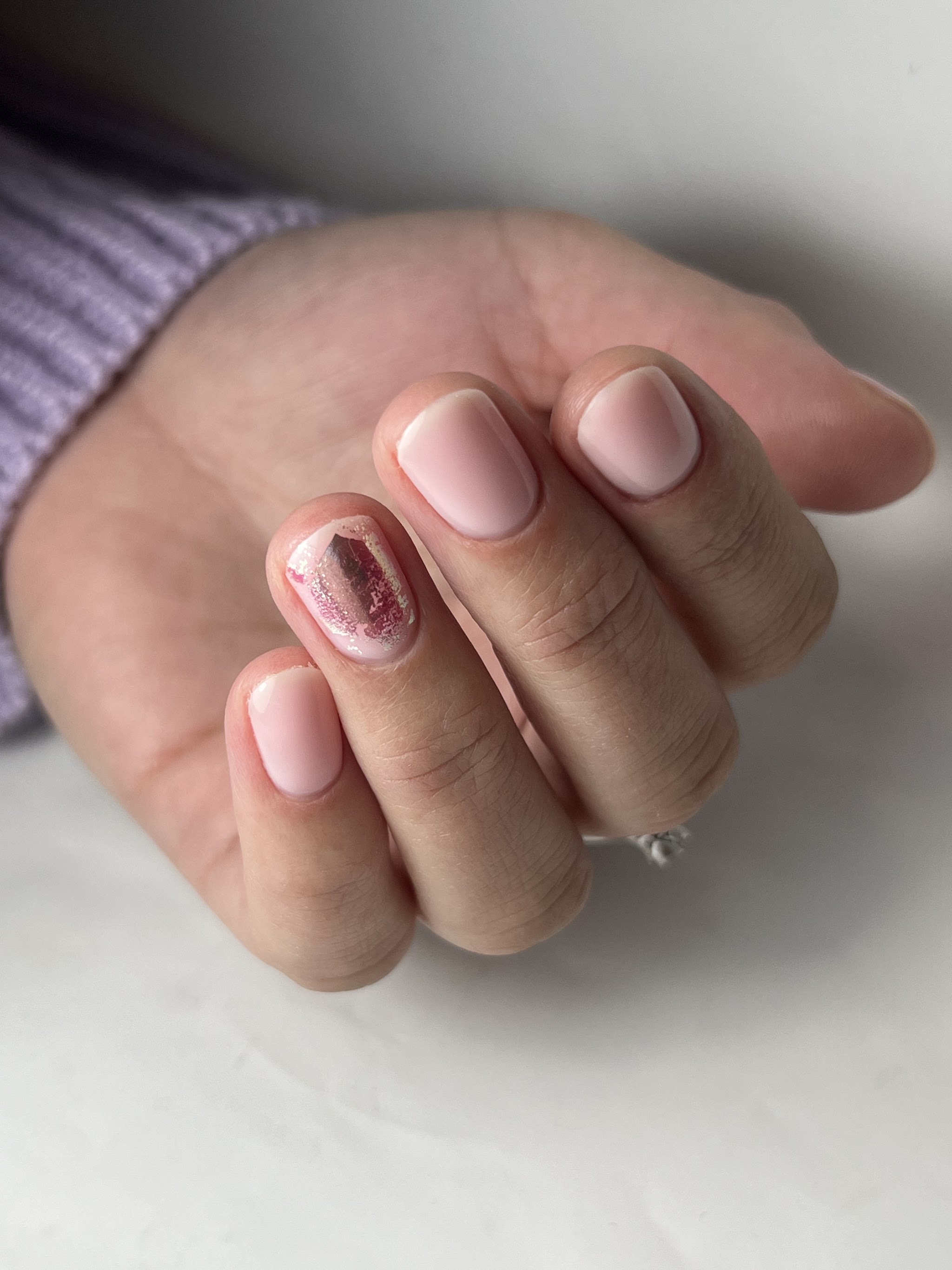 Korte lichtroze nagels met één glitternagel