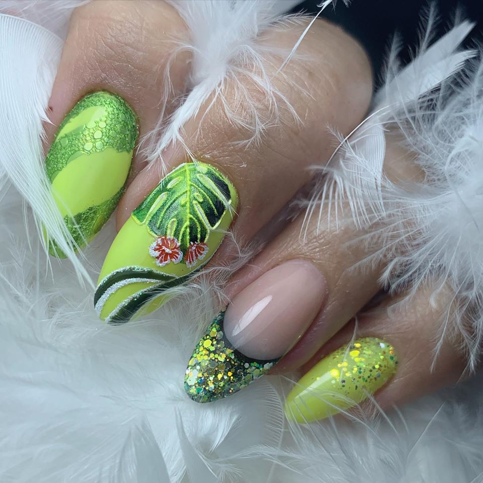 Limoengroene nagels met een tropisch bladontwerp en witte veertjes